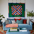  More the Merrier 4-Seater Sofa with assorted NiX cushions, placed in front of a storage ottoman holding books - NiX 