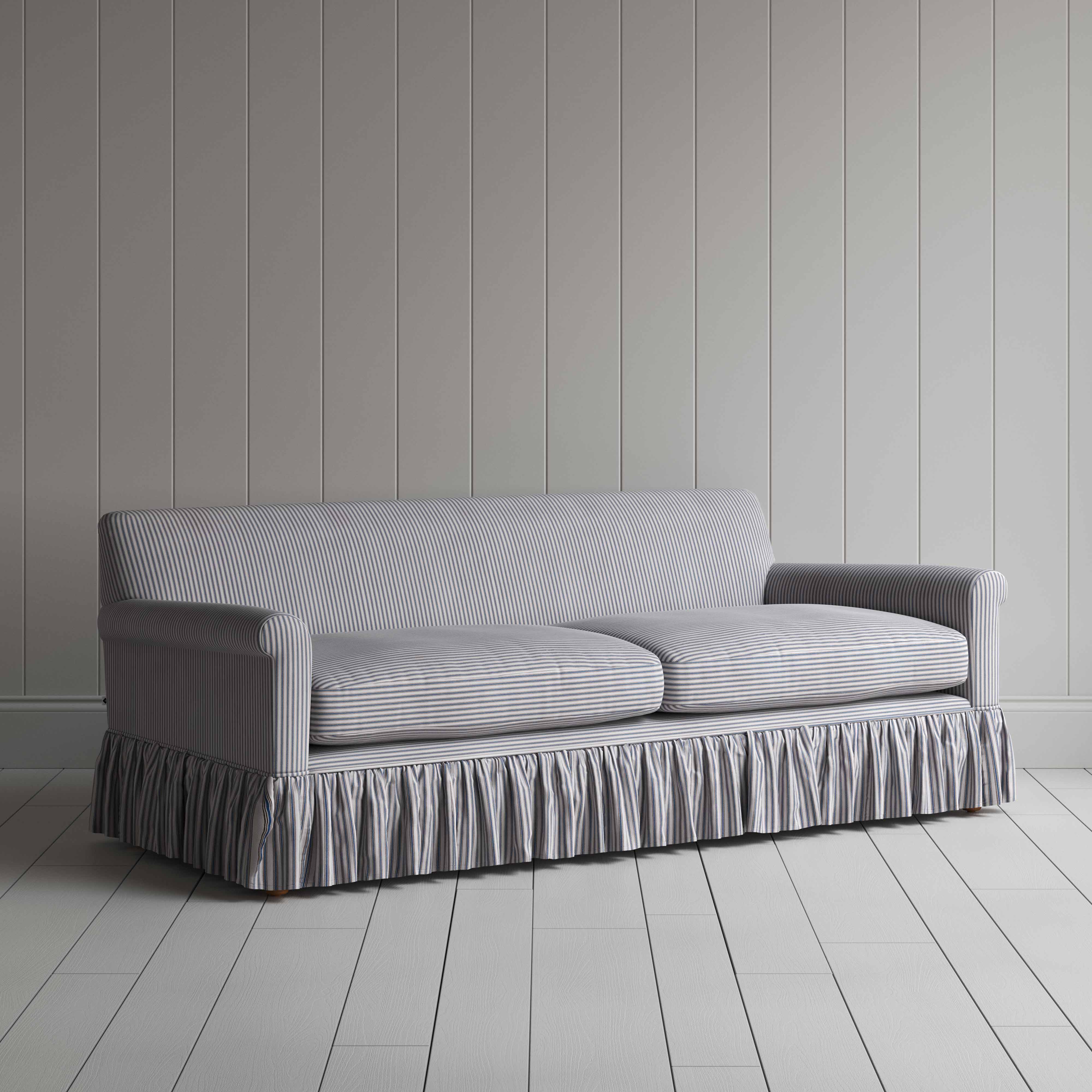  Stylish grey couch with ruffled skirt on wooden floor. 