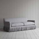  Stylish grey couch with ruffled skirt on wooden floor. 
