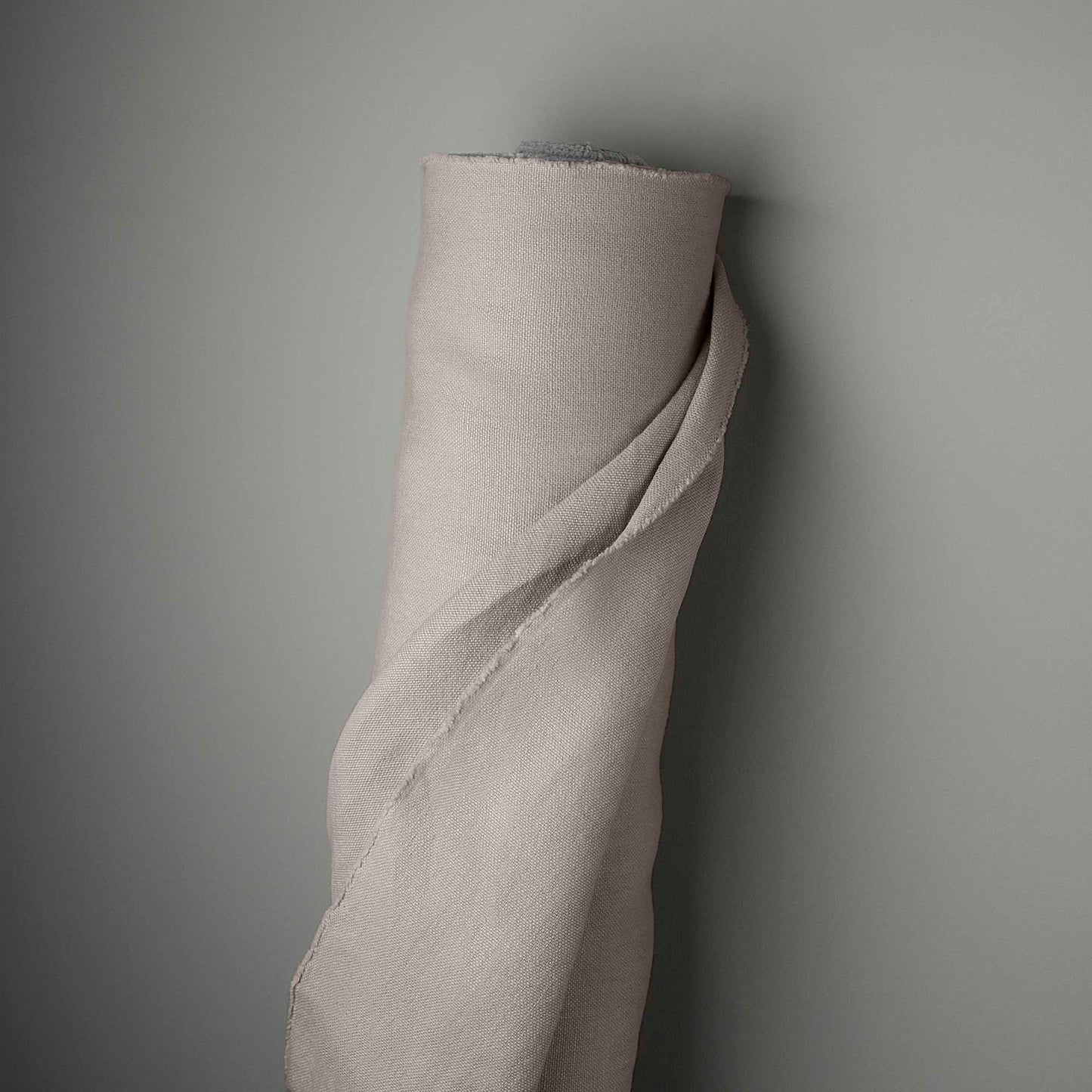 A rolled up piece of fabric hanging on a wall.