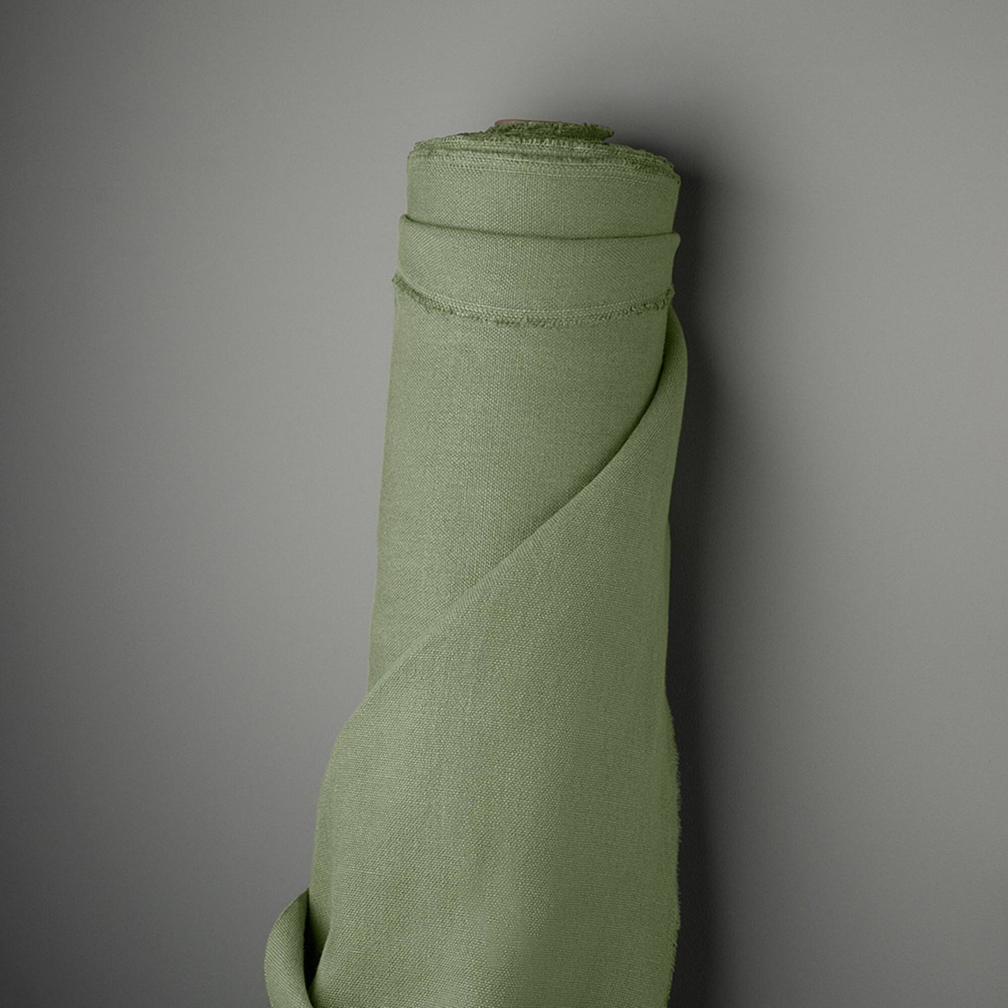 A folded green fabric leaning on a wall.