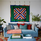  Living room with a velvet sofa adorned with multiple cushions, beautifully designed by Nicola Harding & Co. 