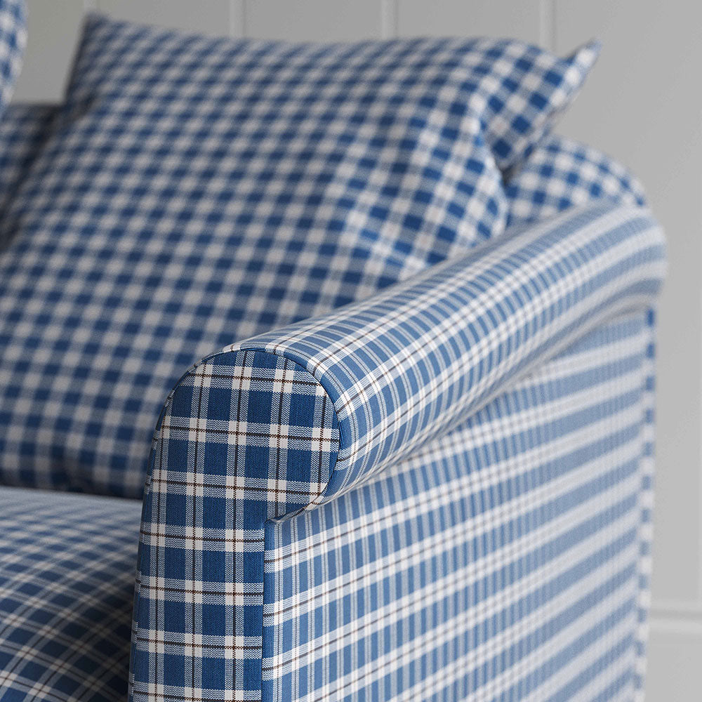  A close up of blue and white checkered sofa with pillows, adding a touch of elegance and comfort to any living space. 