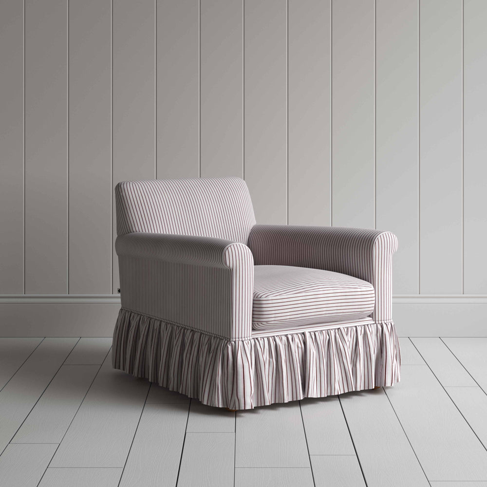 A chair with a ruffled skirt on a white floor.