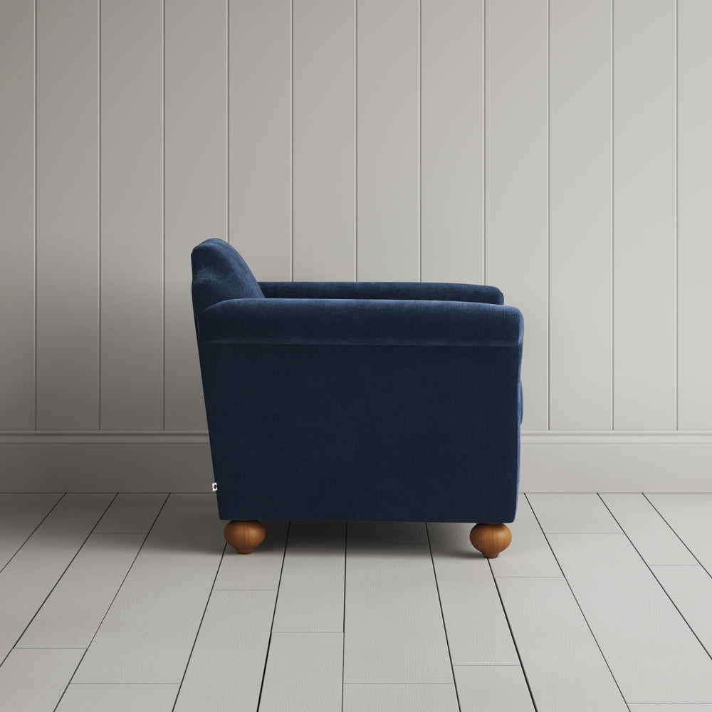 Side profile of the dark blue corduroy Dolittle armchair