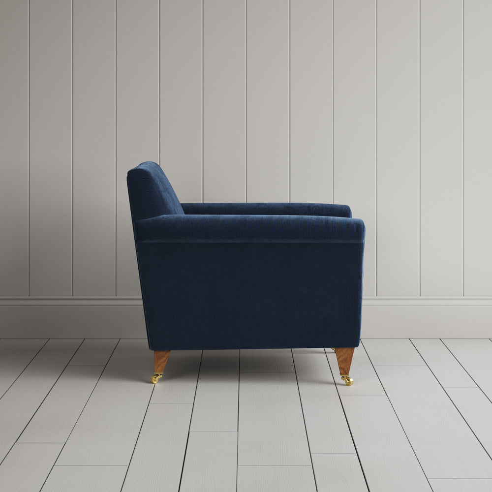  Side profile of the Dark Blue corduroy Idler armchair, featuring a simple Edwardian silhouette. 