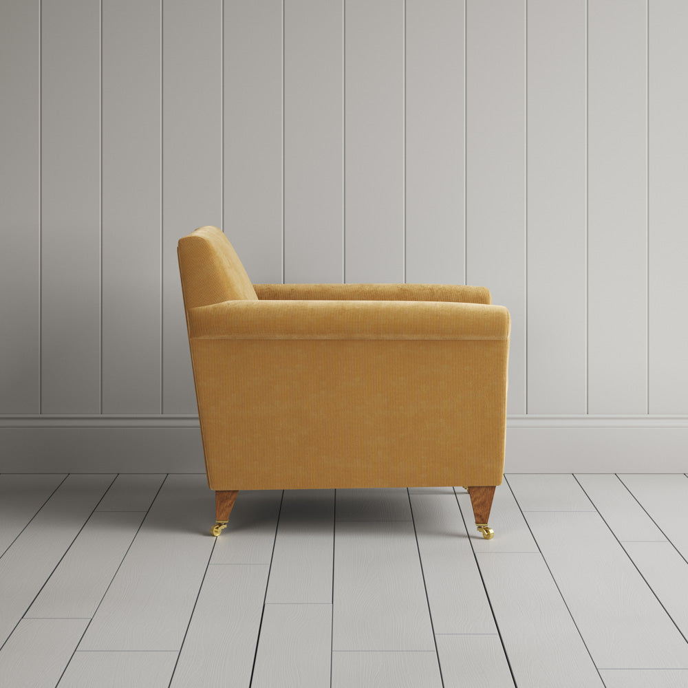 Side profile of the Wheat corduroy Idler armchair, an Edwardian-inspired occasional chair.