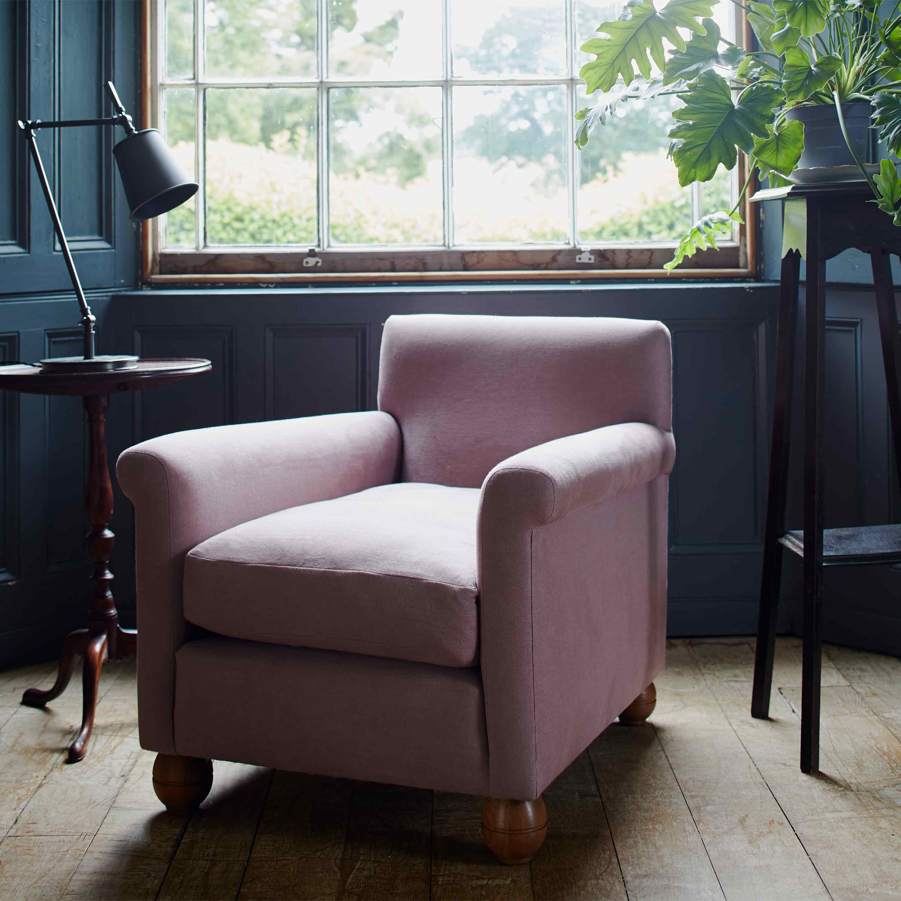  A pink chair placed in front of a window, creating a cozy and inviting spot to relax and enjoy the view. 