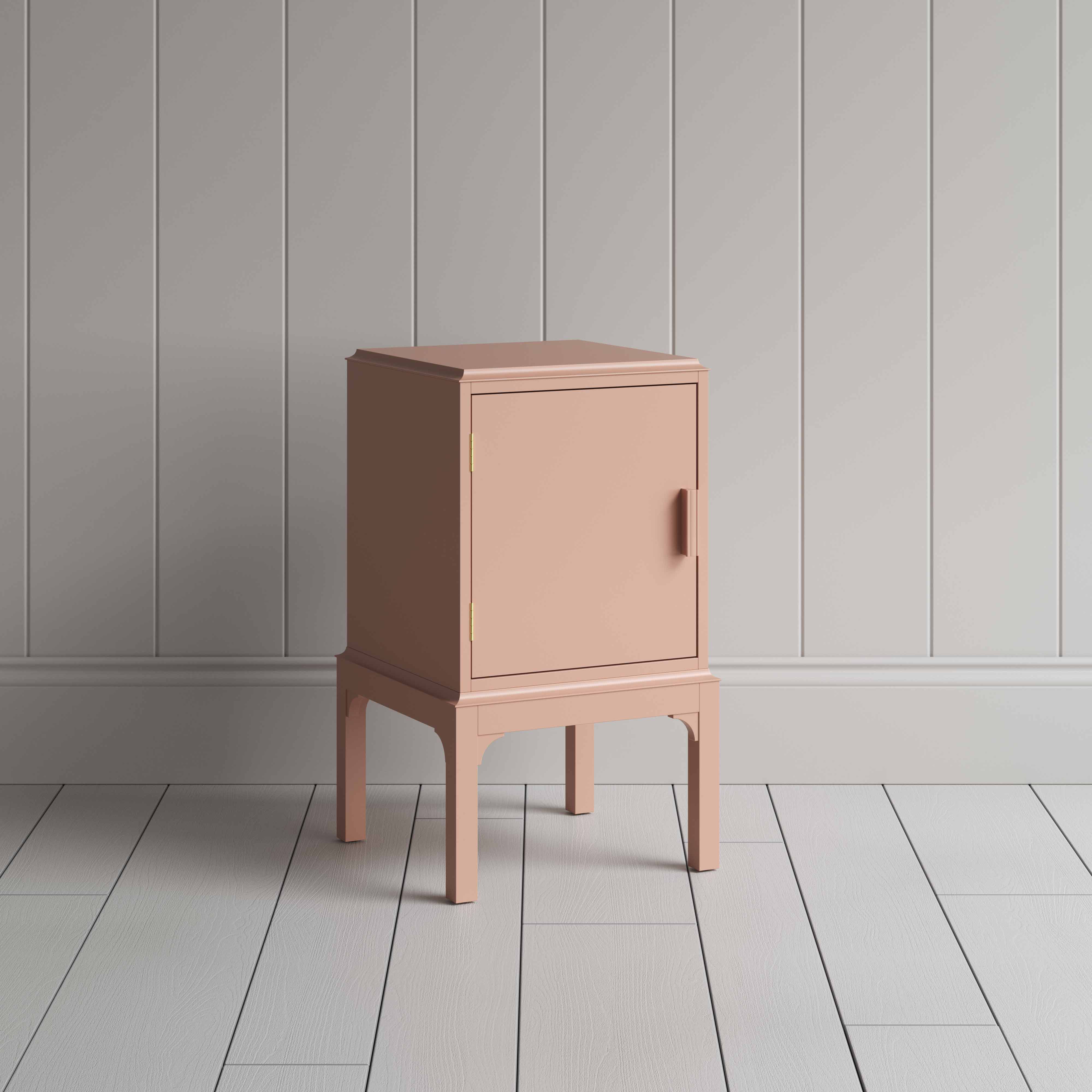  A small pink bedside table with a side door, perfect for storing items discreetly and adding a pop of color to any room. 