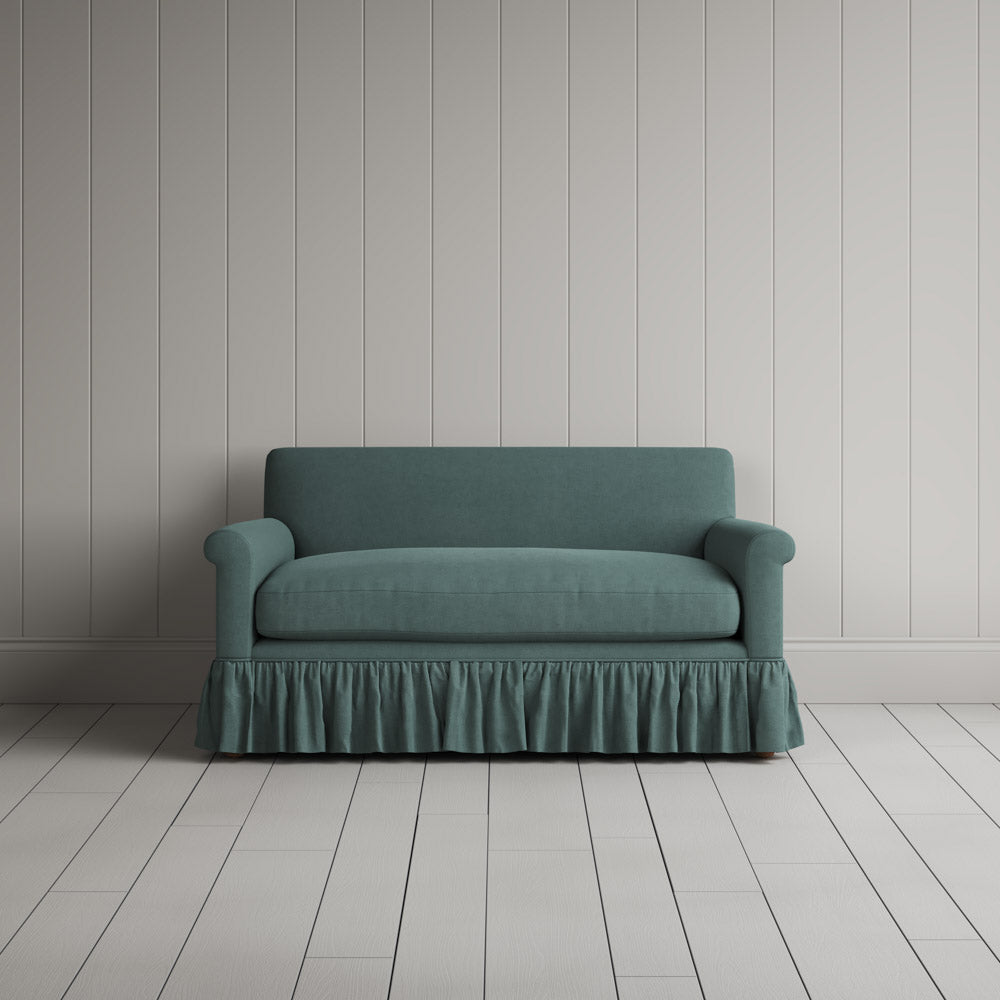  Front view of the Mineral linen nix sofa highlighting its gathered skirt base. 