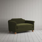 Angled shot of a green upholstered love seats by Nicola Harding.