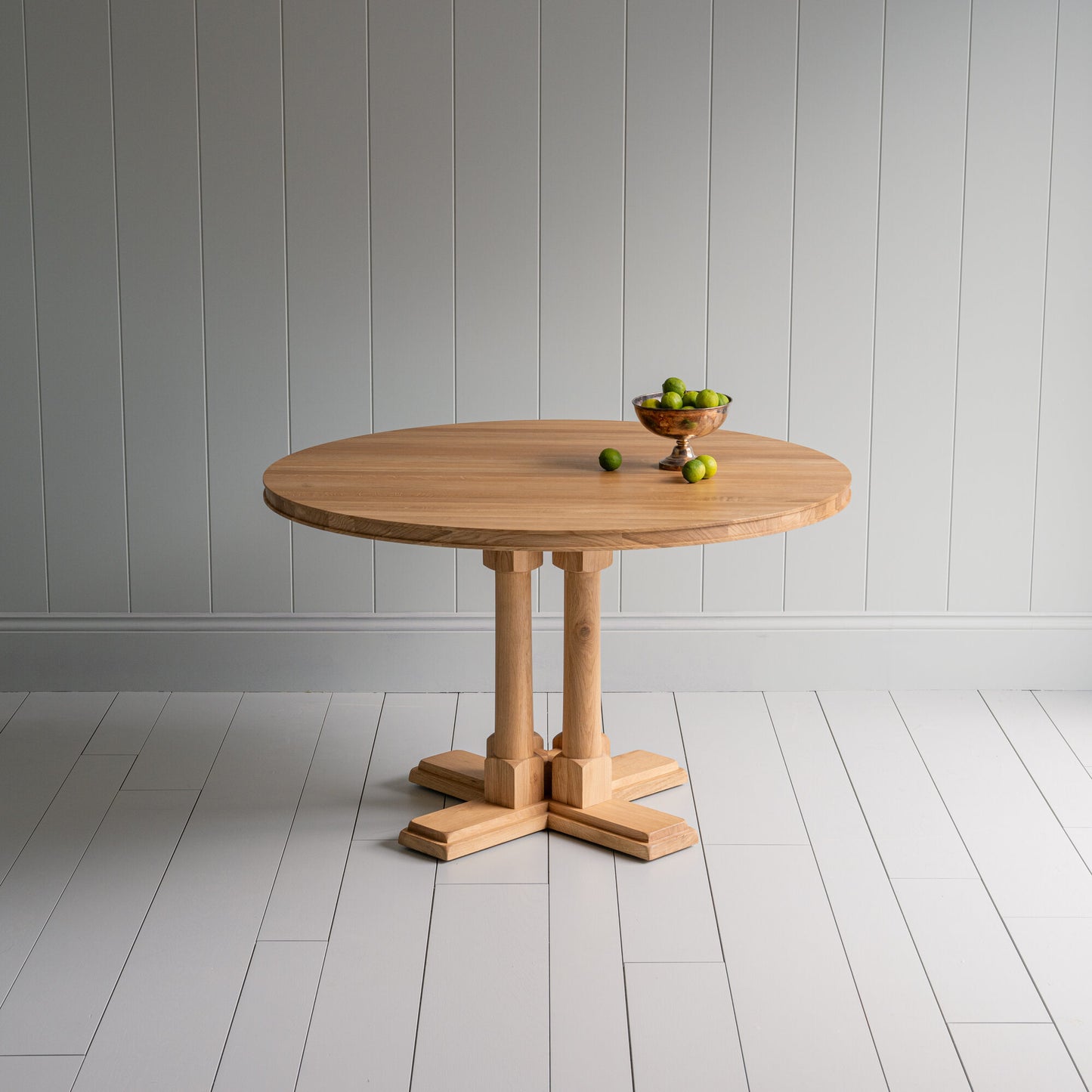 Beautiful small round dining table with a fruit basket on it, manufactured by NiX by Nicola Harding & Co.