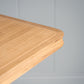 Close-up of the neat edge design on the Tuck In rectangular dining table in oak, designed and manufactured by NiX.
