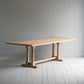 Side tilt view of the Tuck In dining table in lacquered oak.
