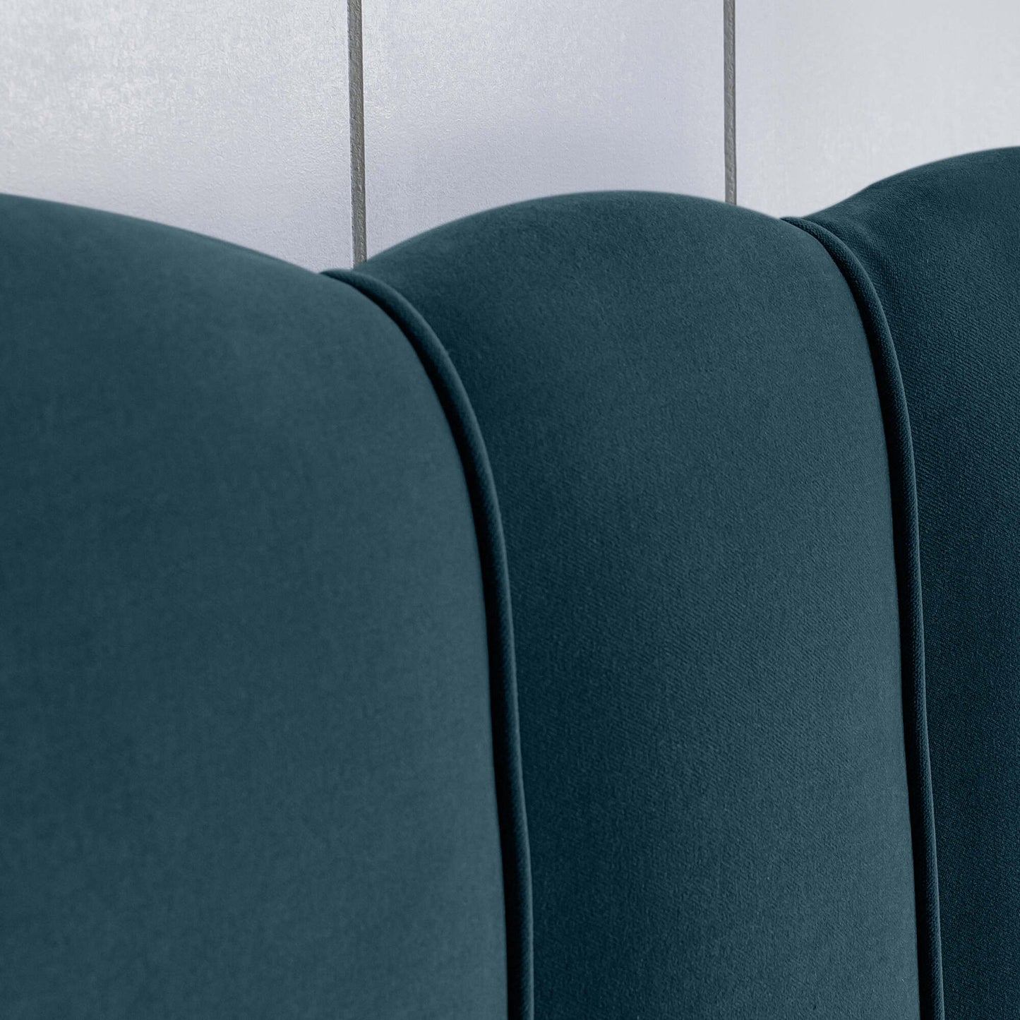 Close-up of the upholstery design on the bed in Intelligent Velvet Aegean fabric, showcasing the sewing details.