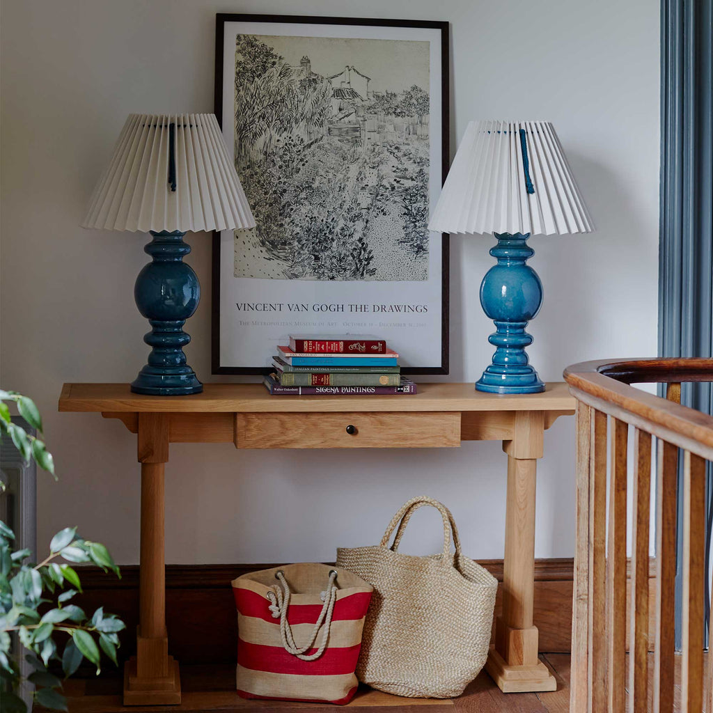  Keepsake Console Table, decorated with 2 lamps and books with a painting by  Nicola Harding & Co. 