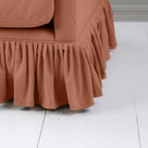  Zoomed-in view of a couch with a stylish ruffled skirt, perfect for creating a cozy and inviting atmosphere in any room. 
