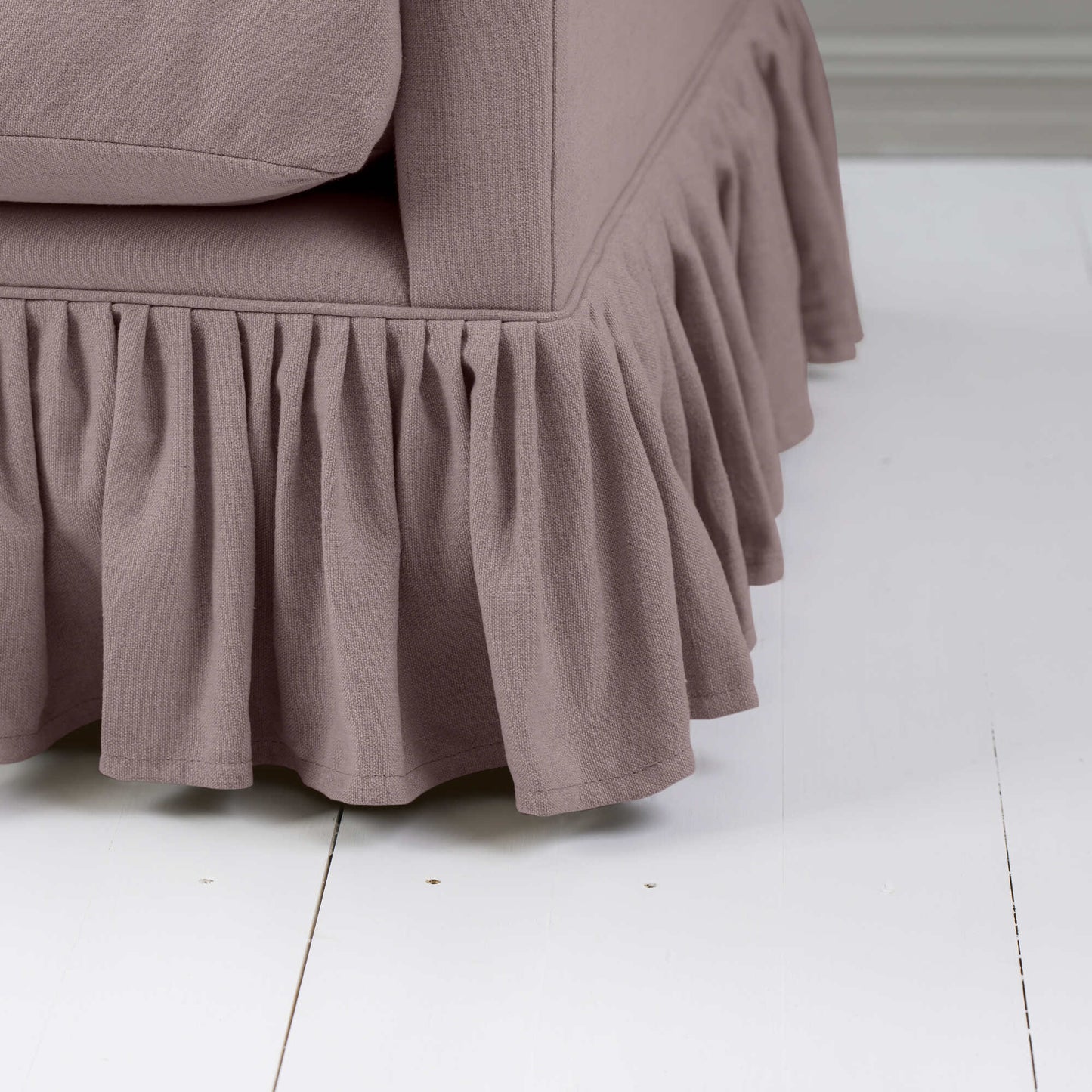 A close-up of a meridian couch with a ruffled skirt, adding elegance and charm to the overall aesthetic.