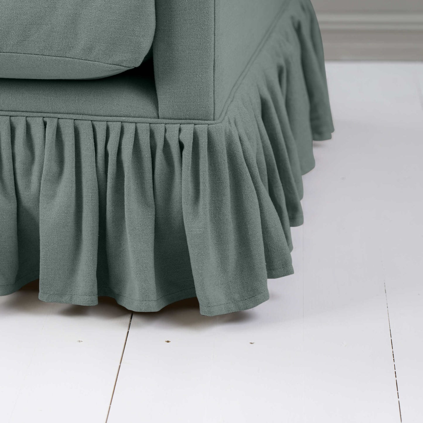 A close-up of a couch with a ruffled skirt, adding elegance and charm to the overall aesthetic.