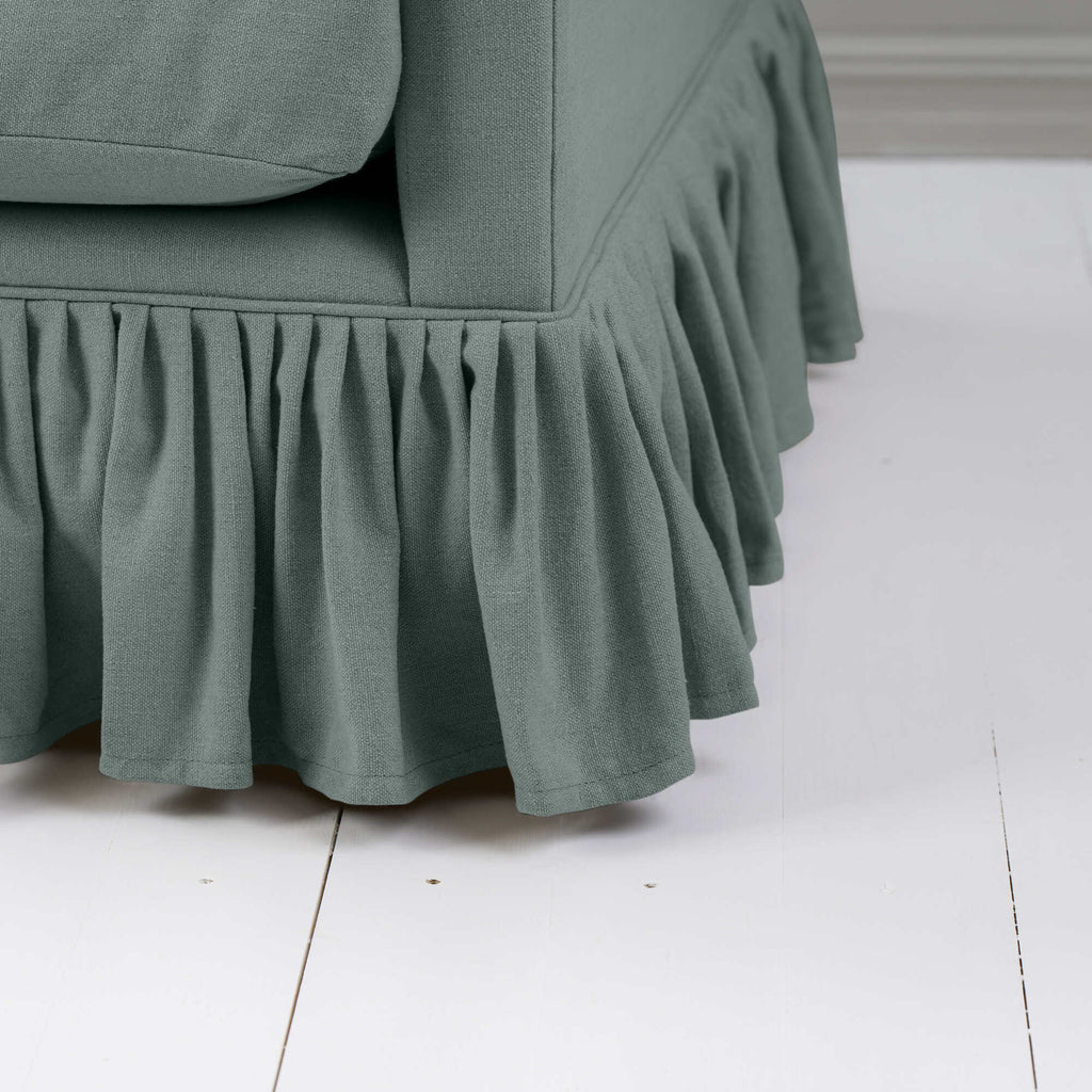  A close-up of a couch with a ruffled skirt, adding elegance and charm to the overall aesthetic. 