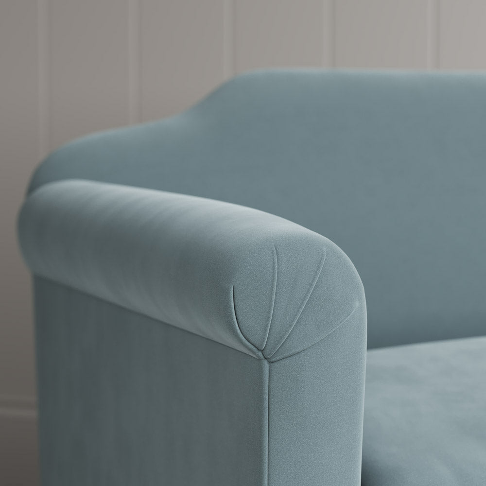  Close-up of the tailored scroll armrest on the Dolittle velvet sofa by NiX. 