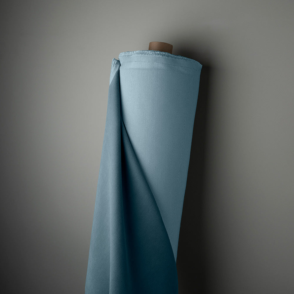 Rolled blue cloth hanging on wall, adding color and texture to the room decor.