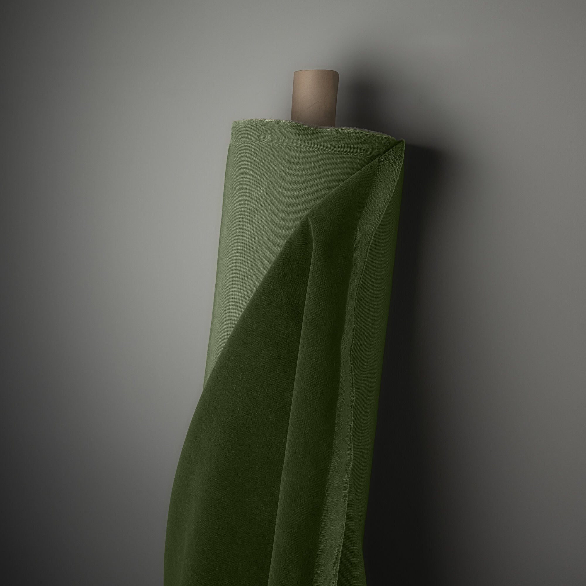  A green cloth is tightly wrapped around a sturdy wooden pole, creating a vibrant and eye-catching contrast. 