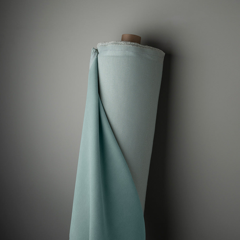  A roll of blue fabric hanging on a wall, adding a touch of color and texture to the space. 