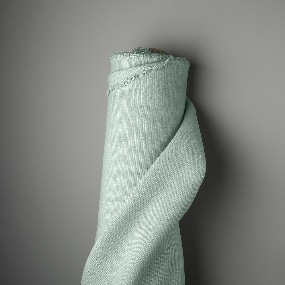  Light green fabric roll on gray background 