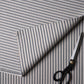 Scissors on a striped fabric.