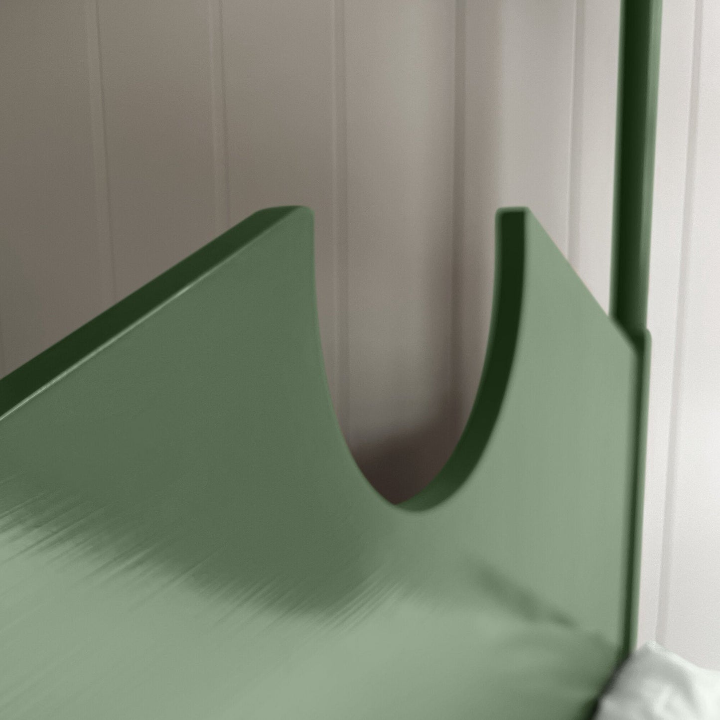 A green metal bed with a white pillow, providing comfort and style to any bedroom decor.