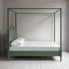  A green canopy bed with crisp white sheets, creating a serene and elegant atmosphere. 
