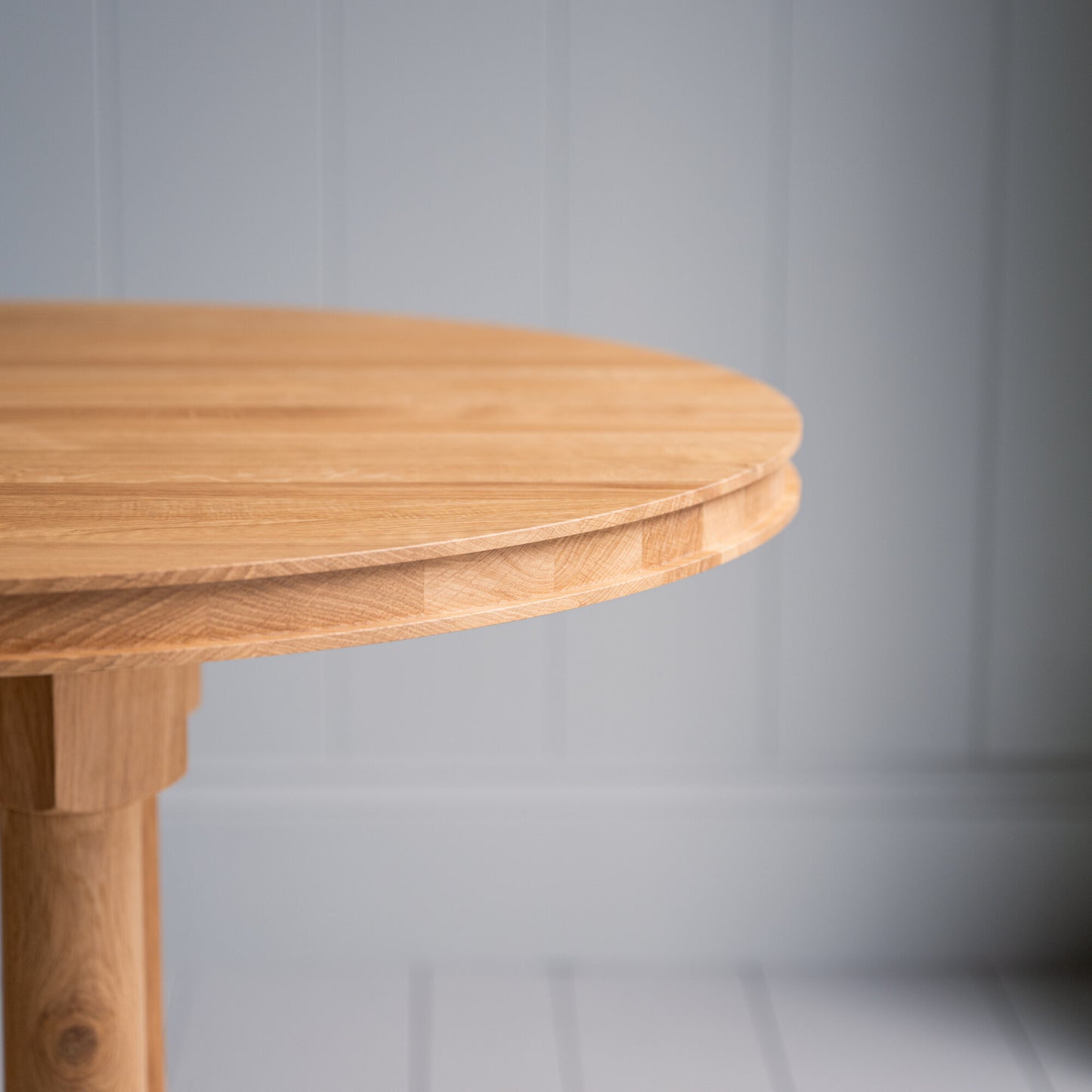 Edge design of the round lacquered oak wood dining table, highlighting its smooth finish and craftsmanship.