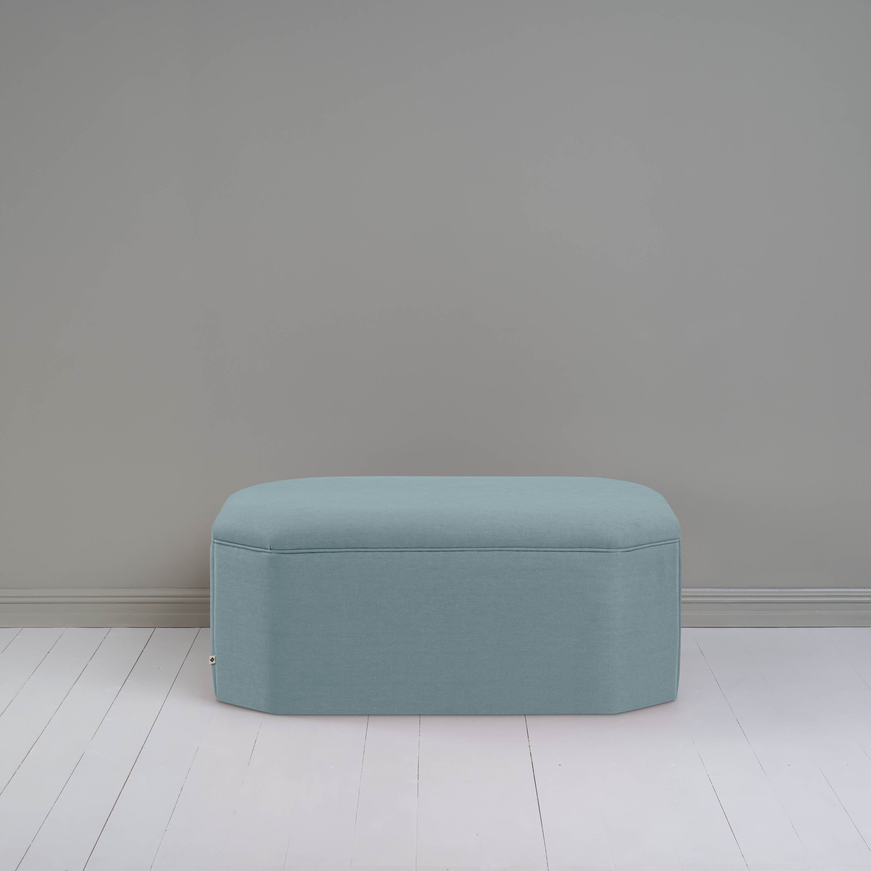  A small light blue ottoman, perfect for adding a touch of color and comfort to any room. 