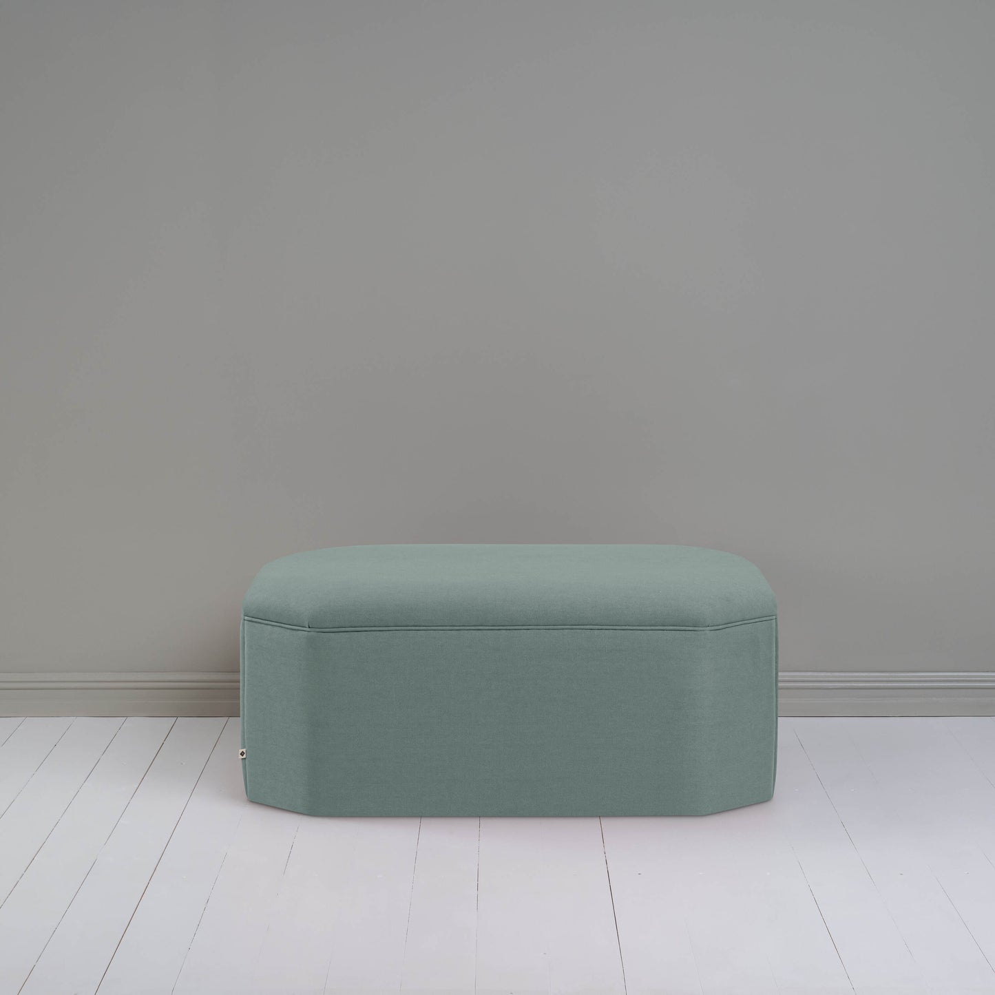 A small light blue ottoman, perfect for adding a touch of color and comfort to any room.