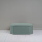 Blue ottoman against gray wall in room. 