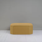  Ottoman against gray wall in room. 