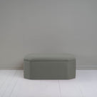  A small light gray ottoman, perfect for adding a touch of color and comfort to any room. 