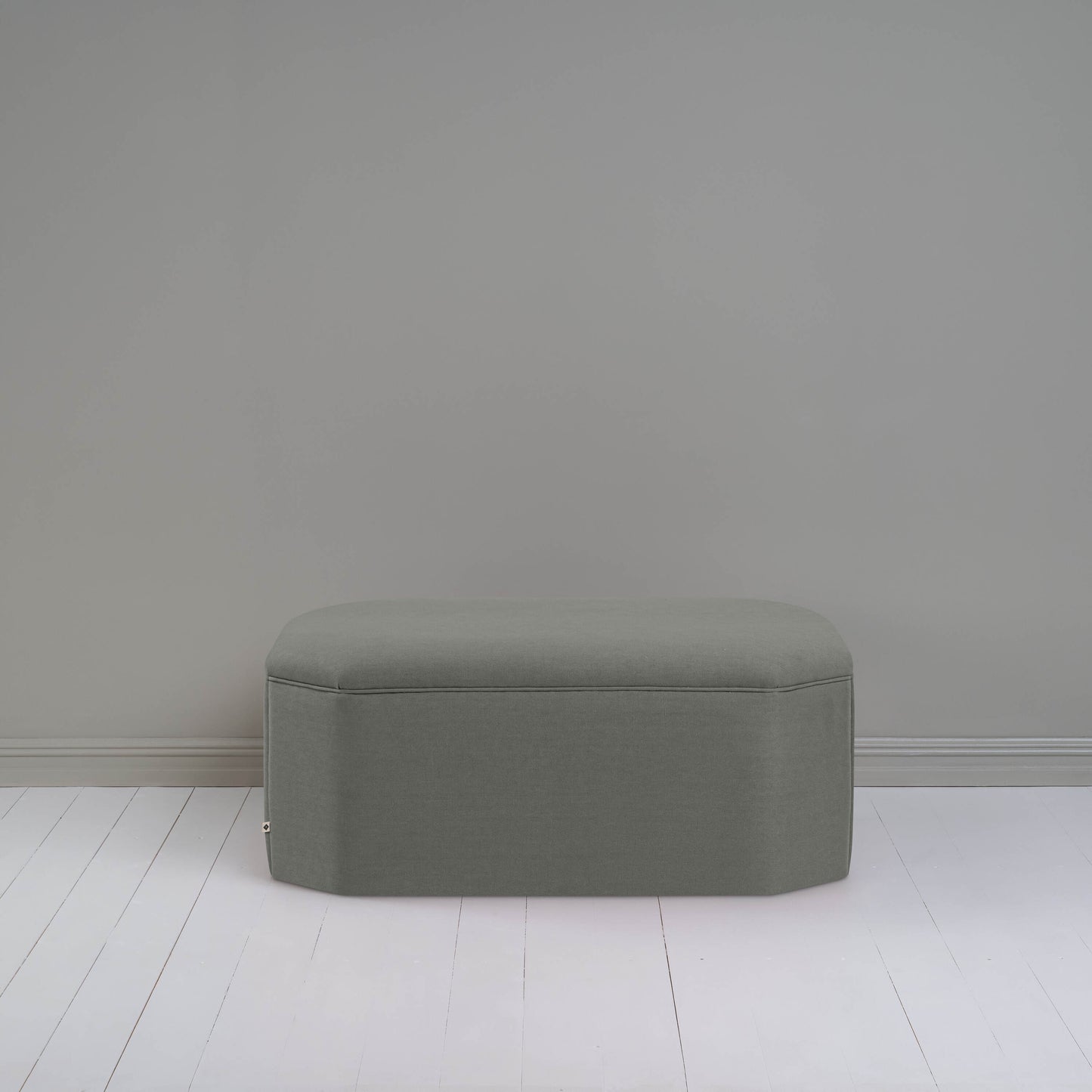 A small gray ottoman, perfect for adding a touch of color and comfort to any room.