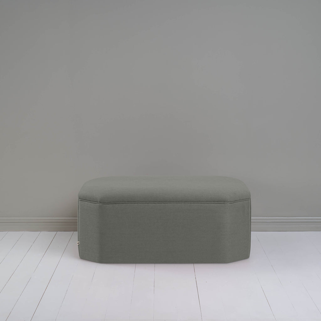  A small gray ottoman, perfect for adding a touch of color and comfort to any room. 