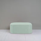  A small light green ottoman, perfect for adding a touch of color and comfort to any room. 