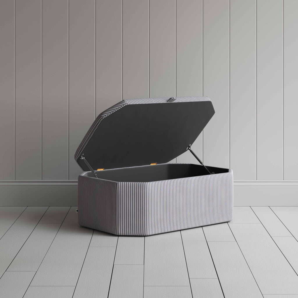  Stylish grey ottoman against white flooring. 