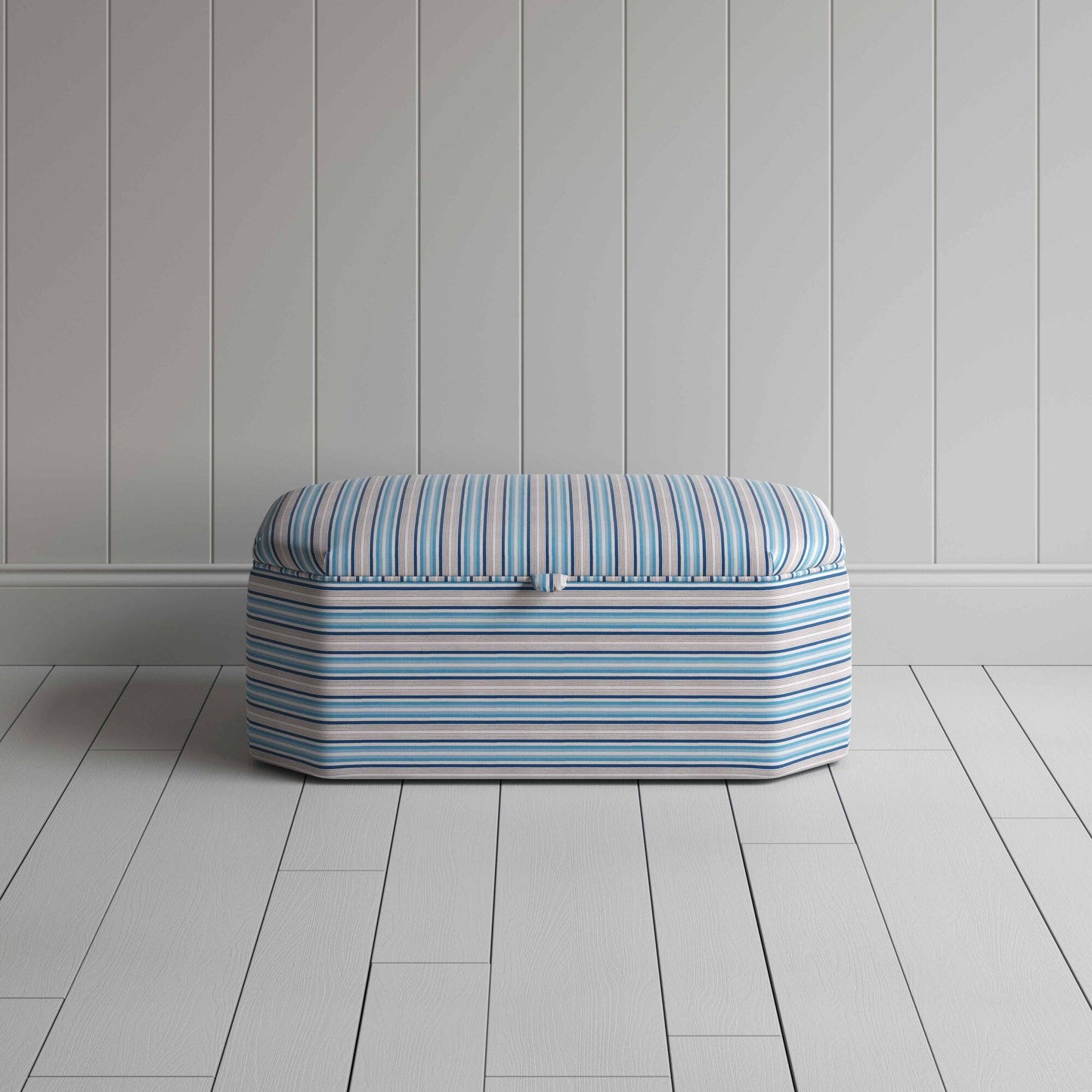 Blue and white striped ottoman on wooden floor.