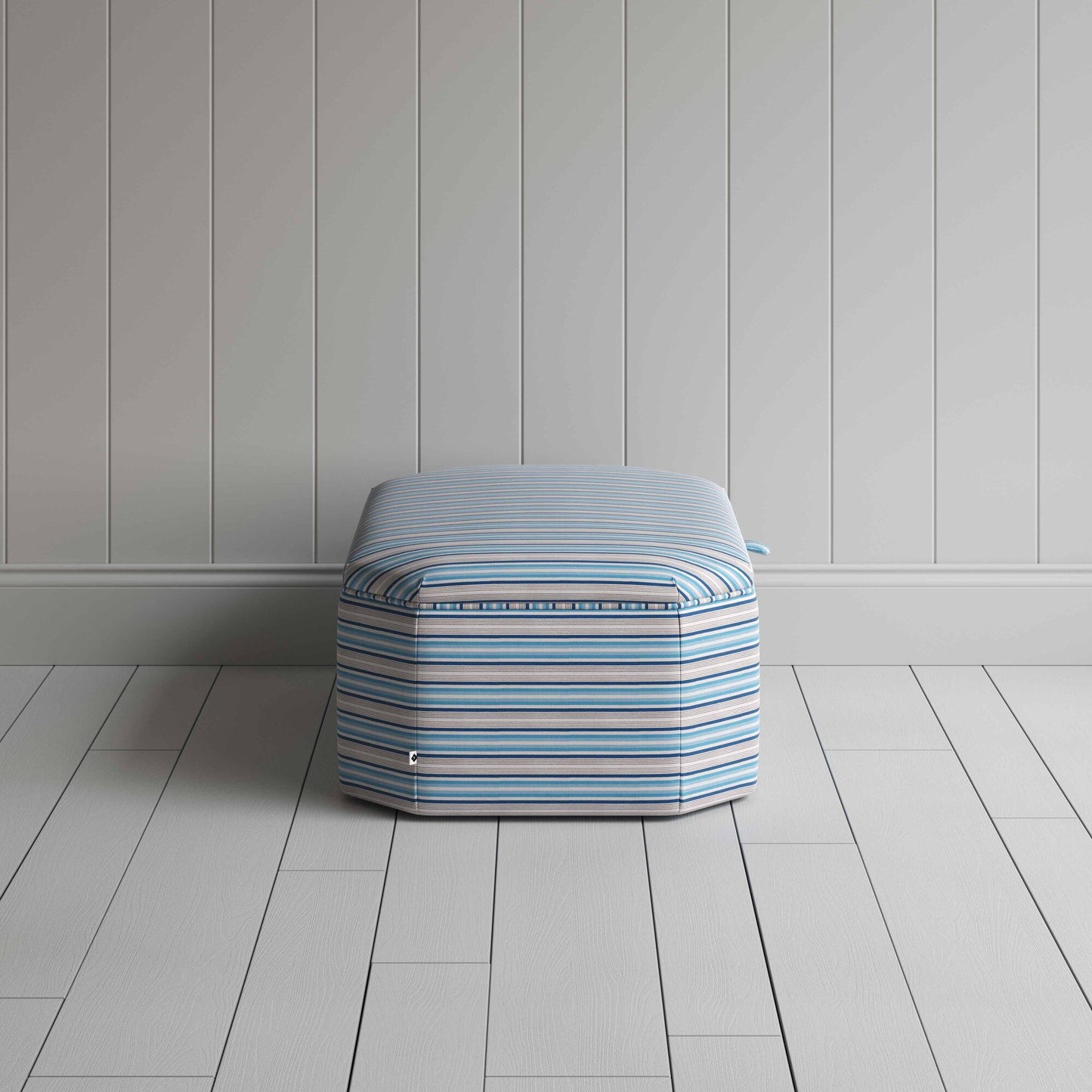 Blue and white striped ottoman on wooden floor.