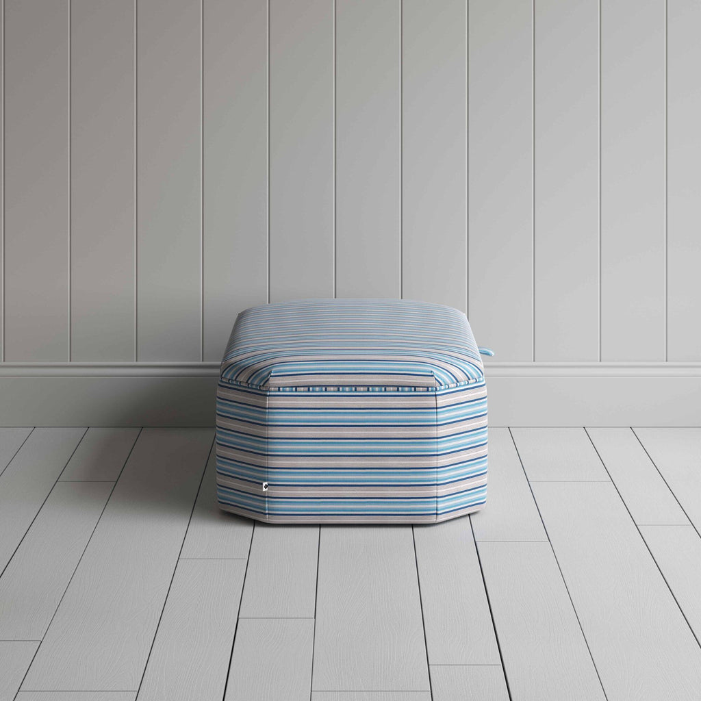  Blue and white striped ottoman on wooden floor. 