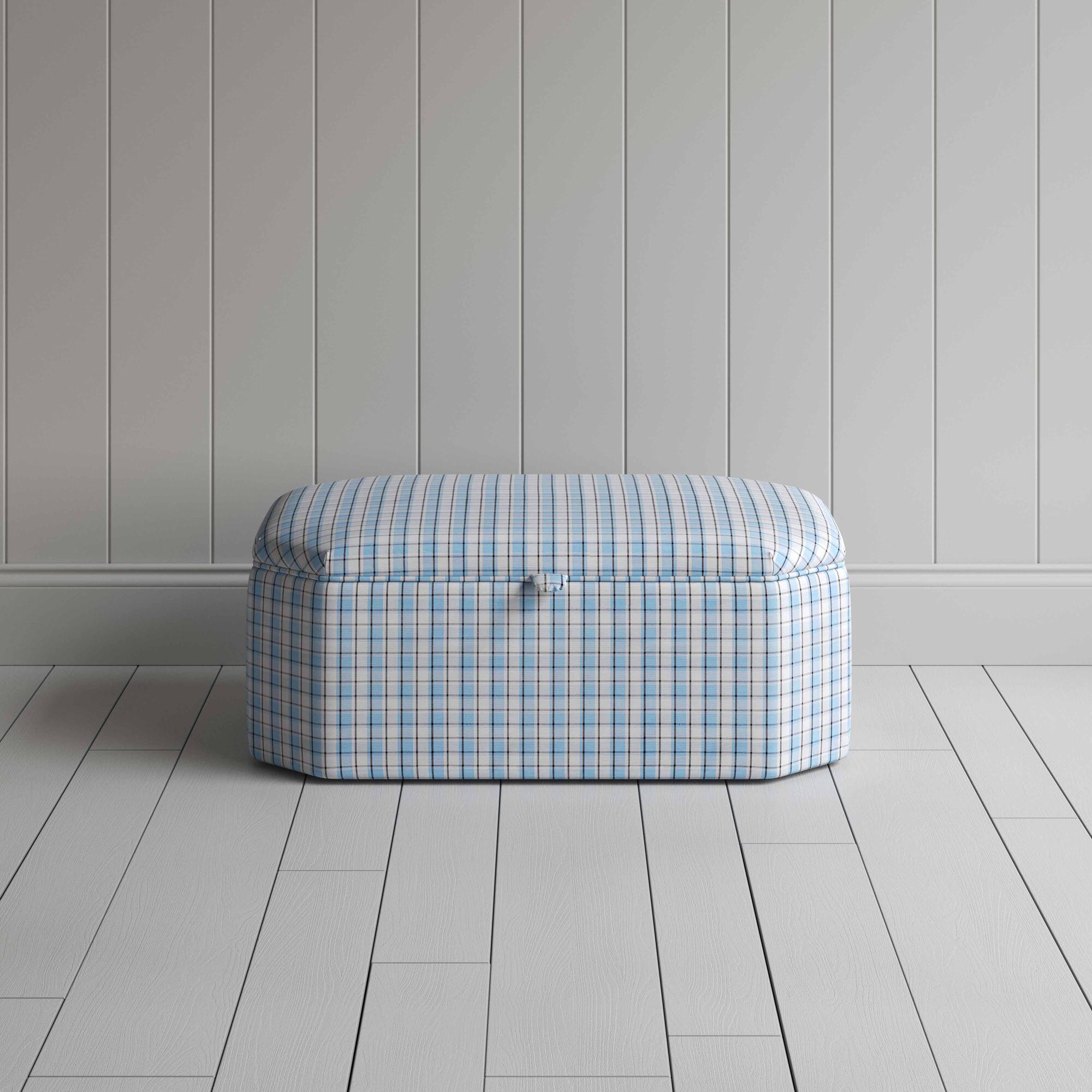  Blue and white checkered ottoman on wooden floor. 