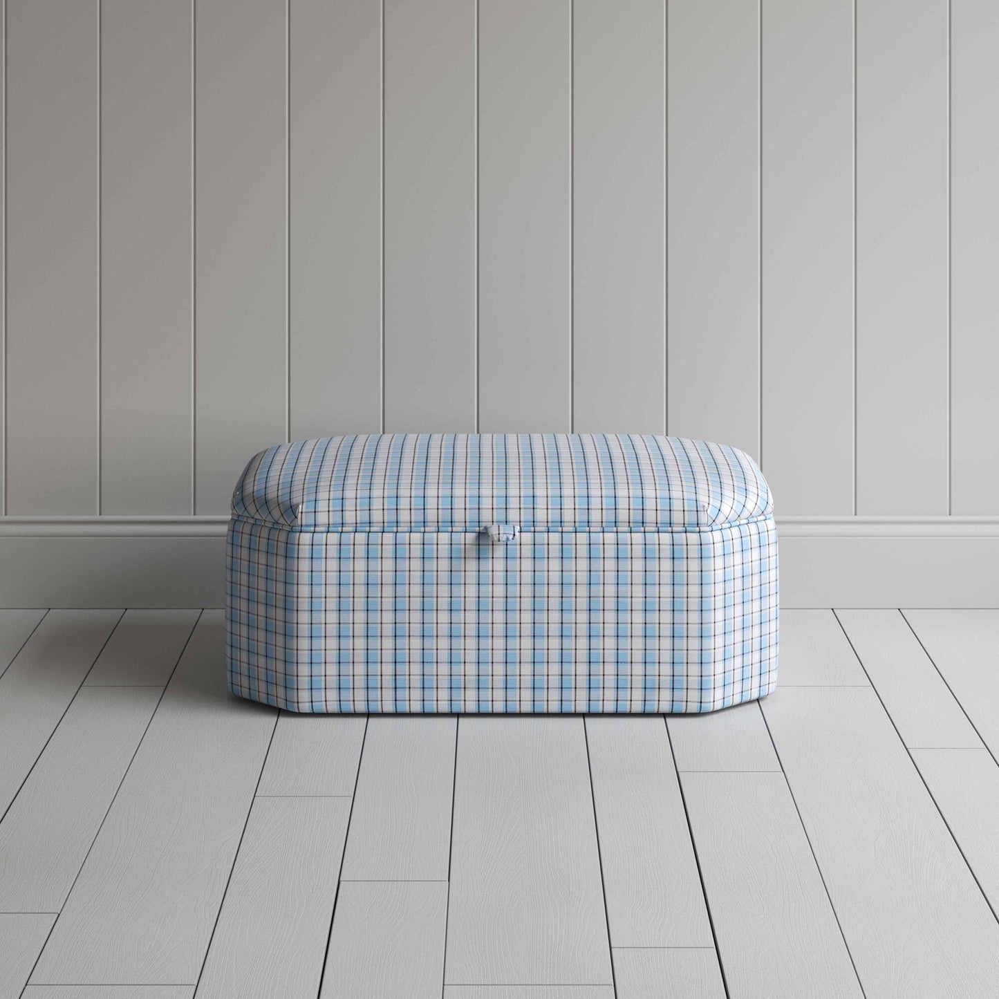 Blue and white checkered ottoman on wooden floor.