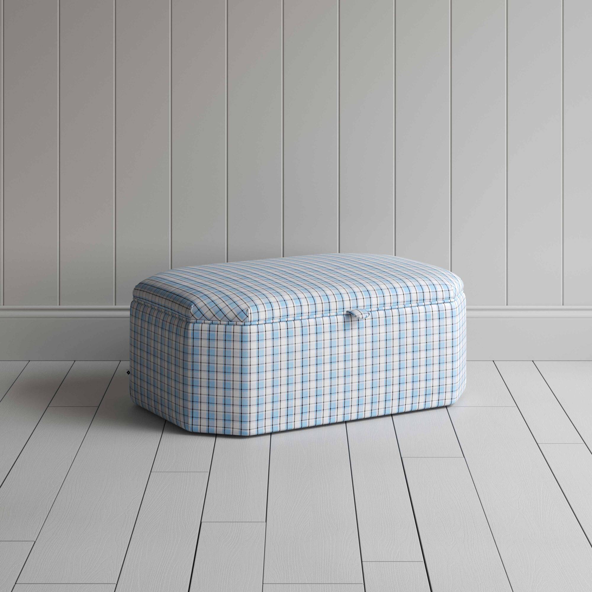  Blue and white checkered ottoman on wooden floor. 