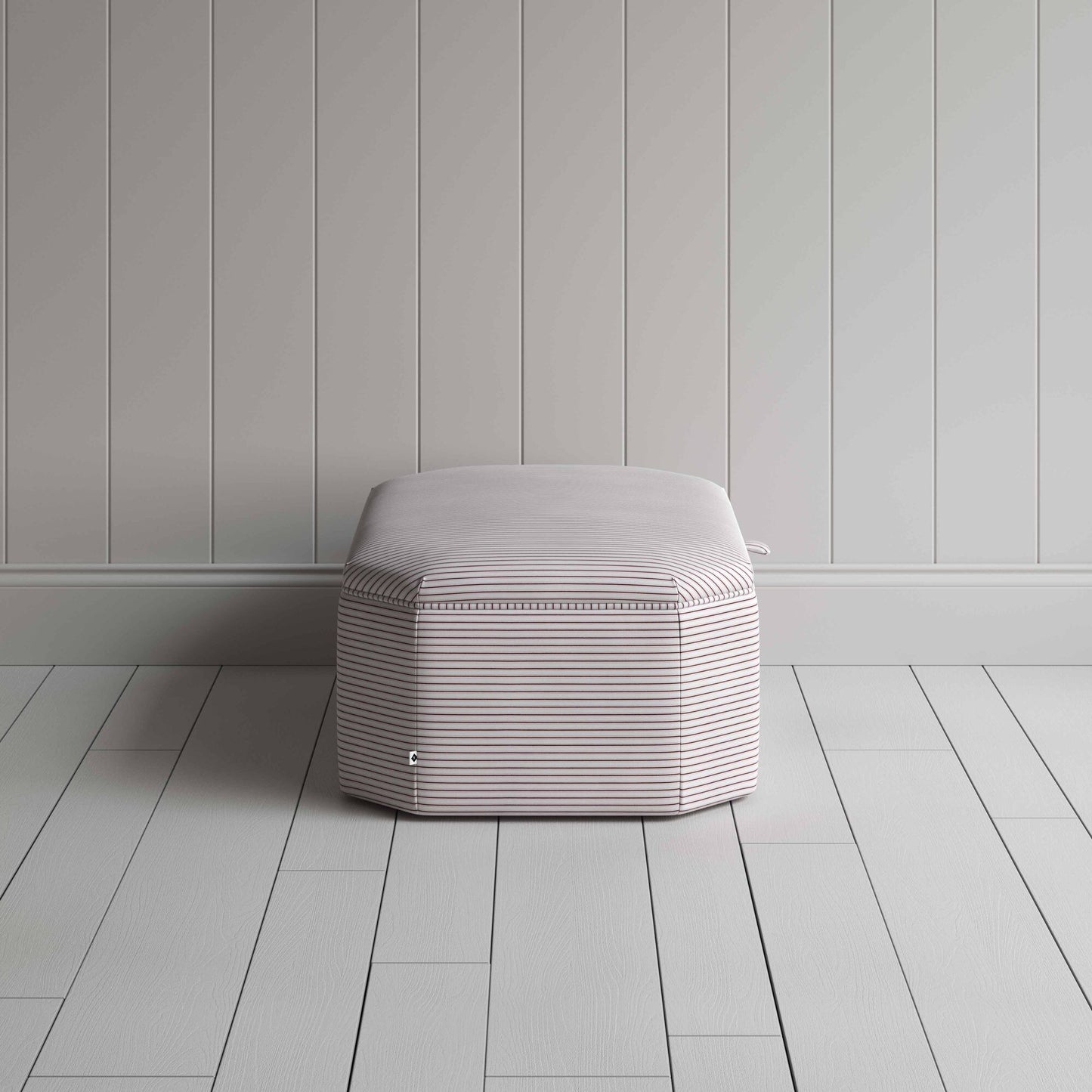 Stylish striped ottoman against white flooring.