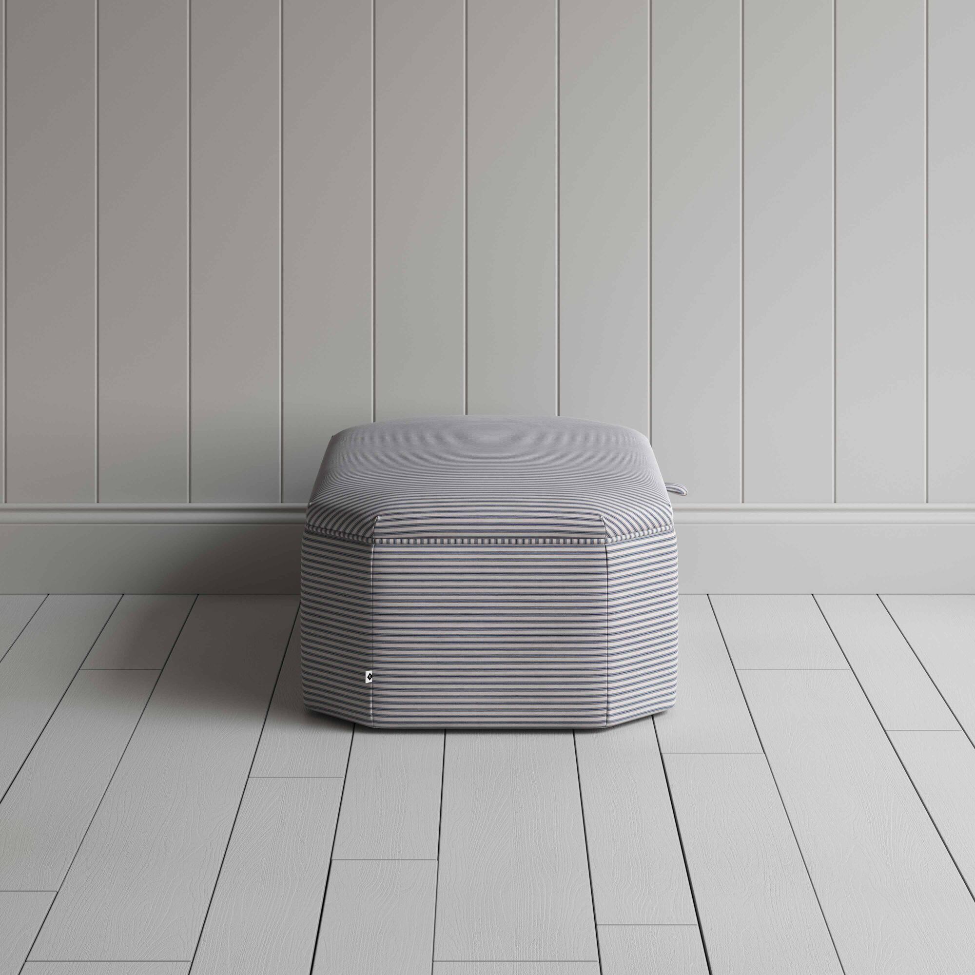  Stylish grey ottoman against white flooring. 